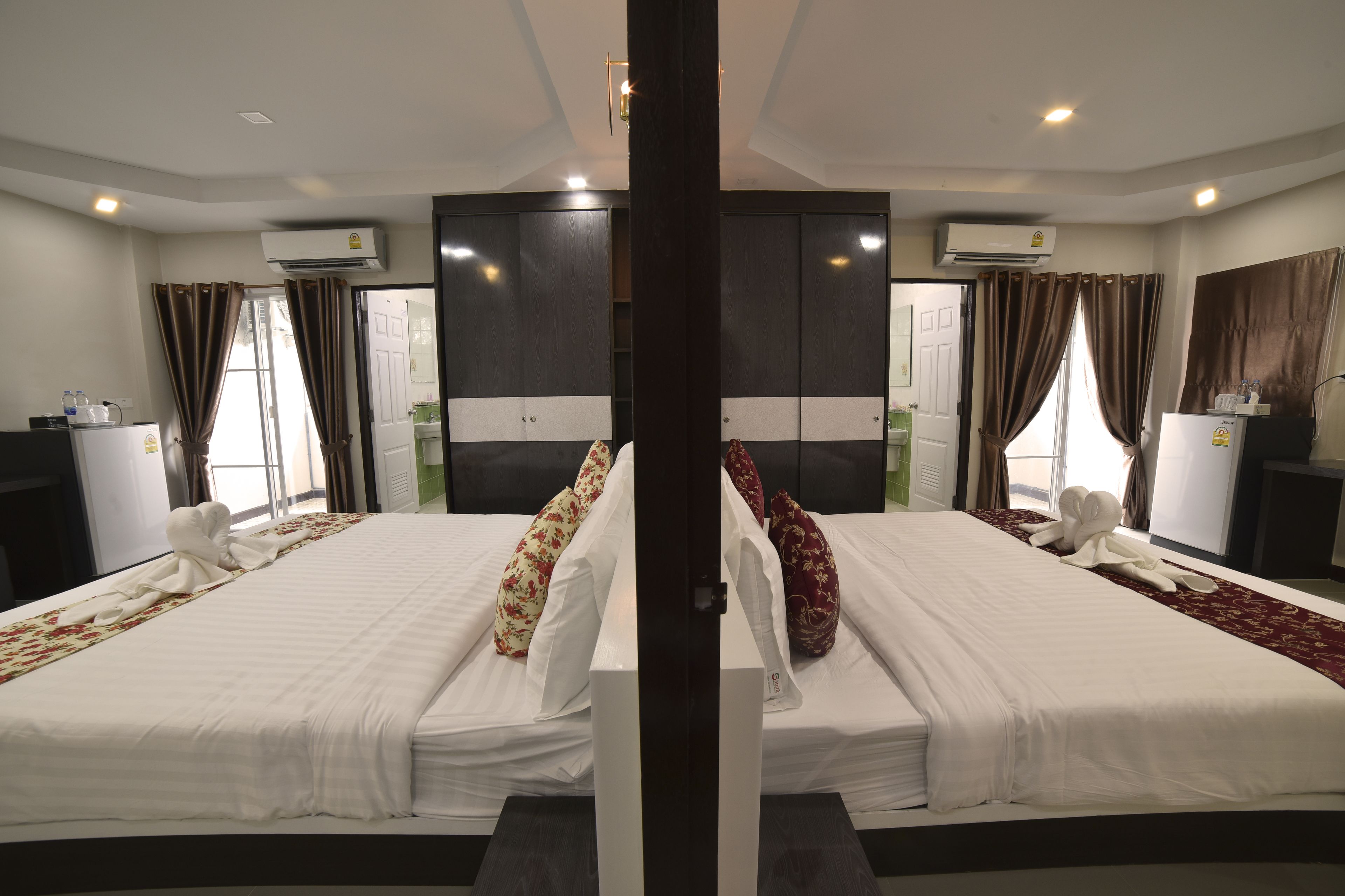 Una habitación de hotel con dos camas, aire acondicionado y un armario.