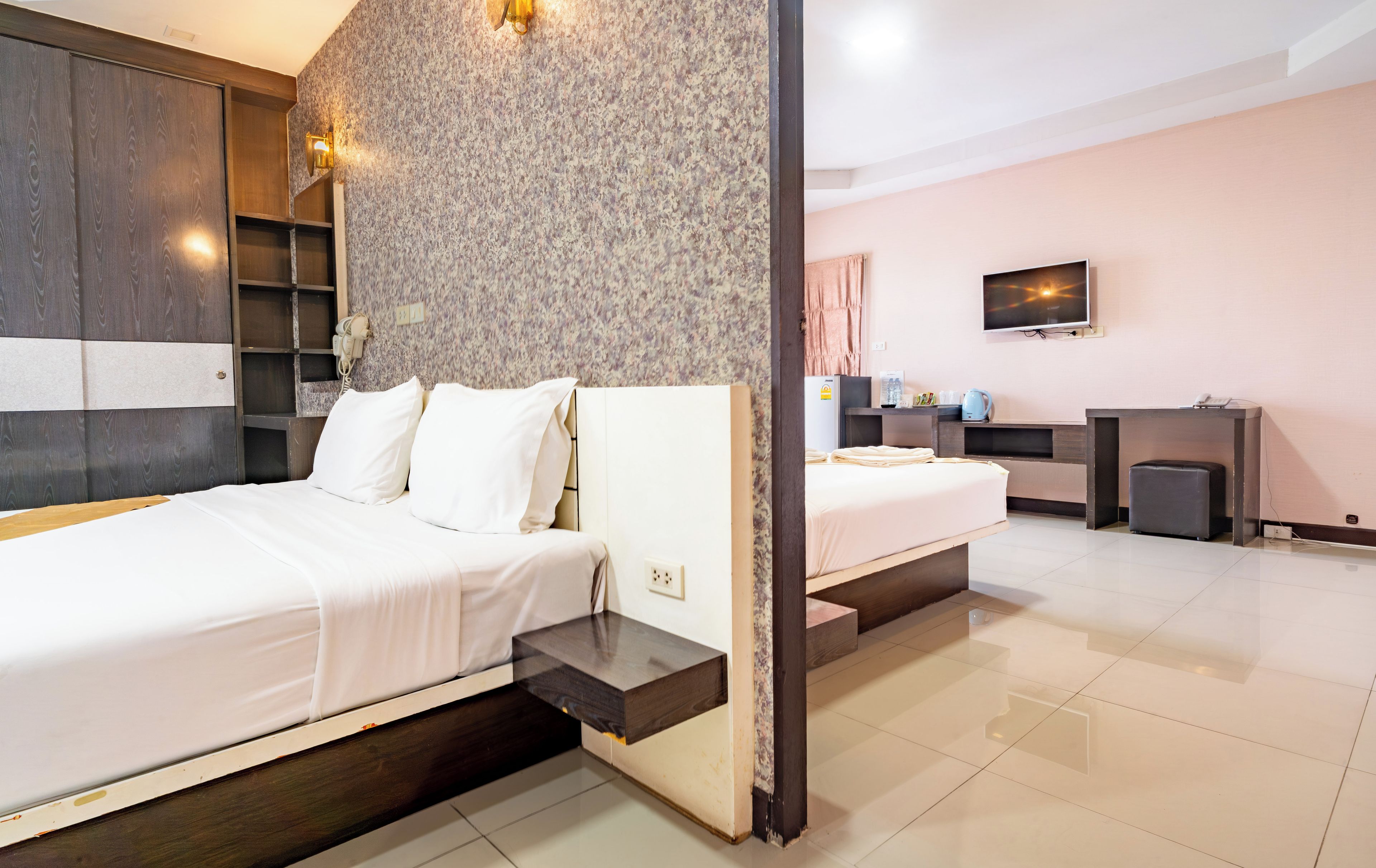 Una habitación de hotel con dos camas, televisión, escritorio y baño.