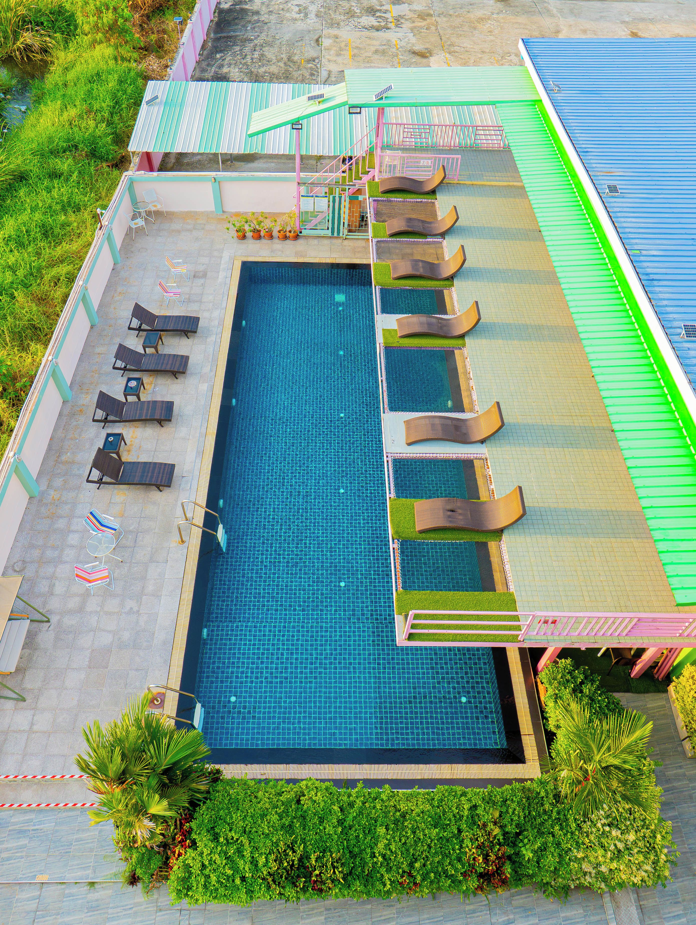 Une piscine avec des chaises longues et un toboggan pour enfants.