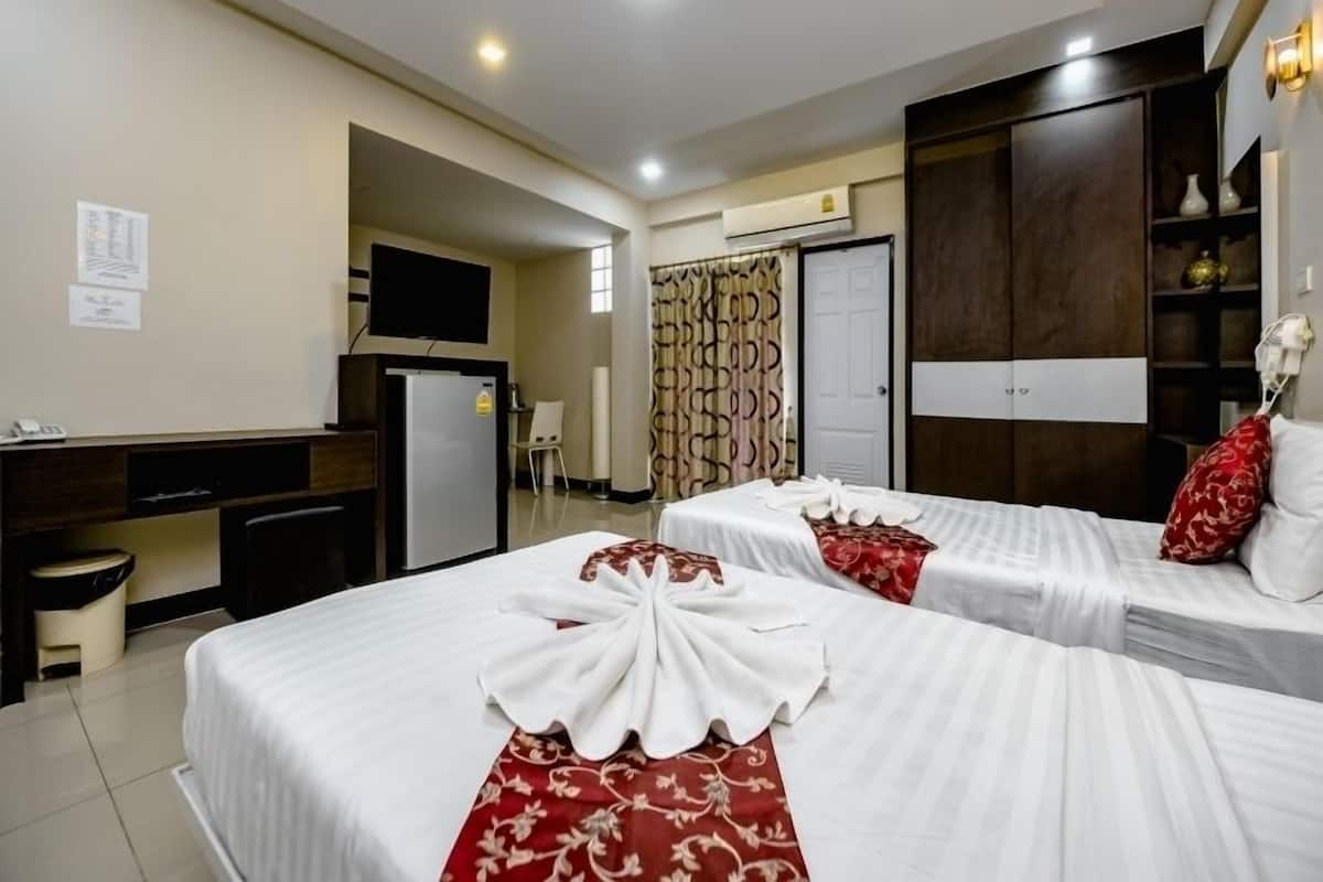 A hotel room with two beds, a desk, a chair, a TV, and a wardrobe.