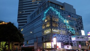 Un edificio moderno con facciata in vetro e insegne illuminate.
