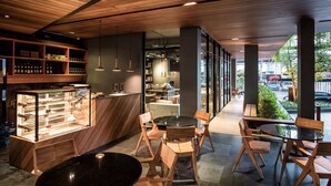 Ein modernes Café-Interieur mit Holzelementen, einer Glasvitrine und verschiedenen Sitzgelegenheiten.