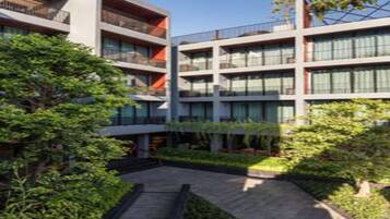 Un edificio moderno de varios pisos con balcones y grandes ventanales.