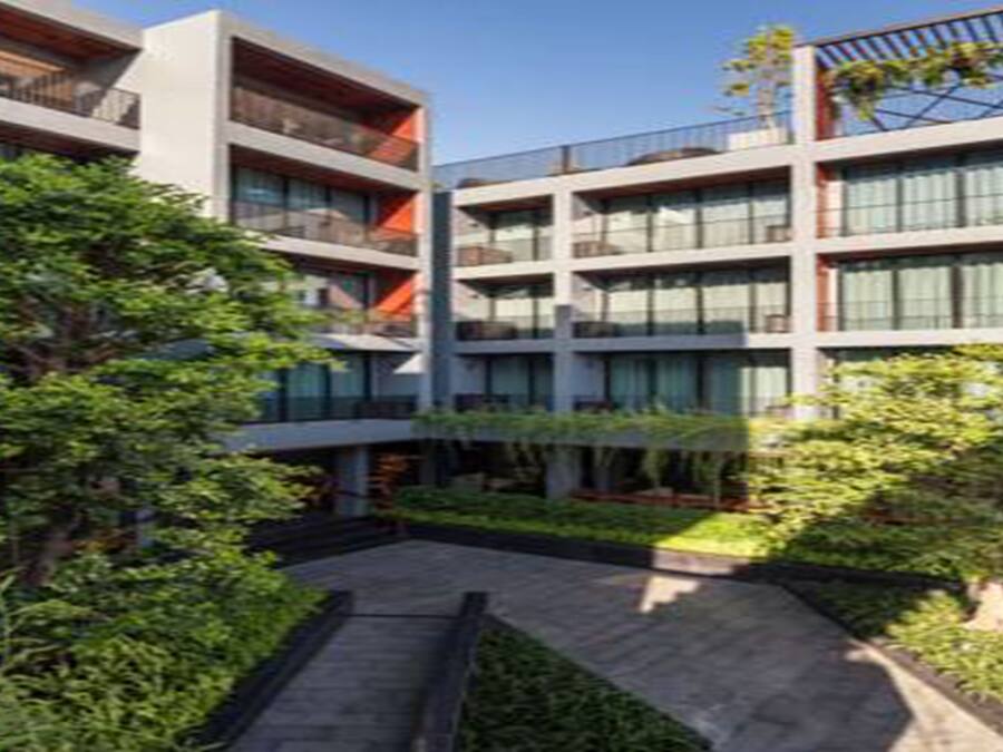 Un edificio moderno de varios pisos con balcones y grandes ventanales.