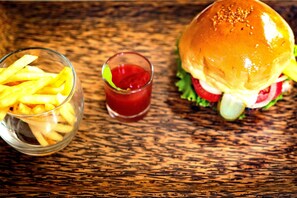 A burger and fries on a wooden table. - Villa Wat Damnak (Siem Reap)