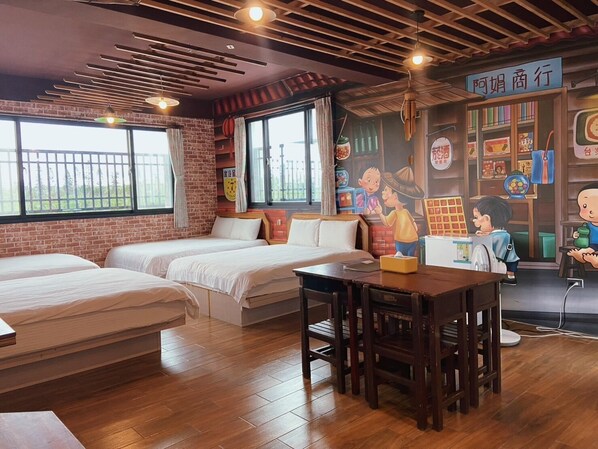 A hotel room with two beds, a wooden table, and a mural on the wall.