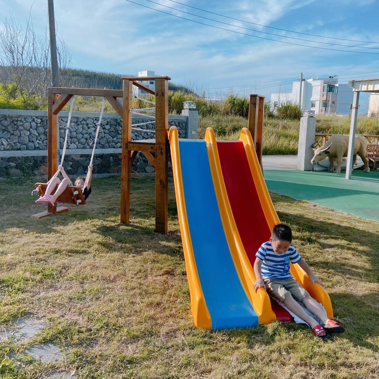 A playground with a slide and swings.