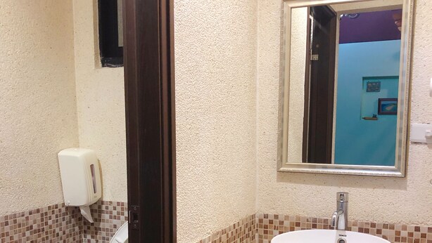Un baño con inodoro, lavabo y espejo.