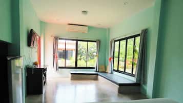 A room with a large window, a flat-screen TV, and a bench.
