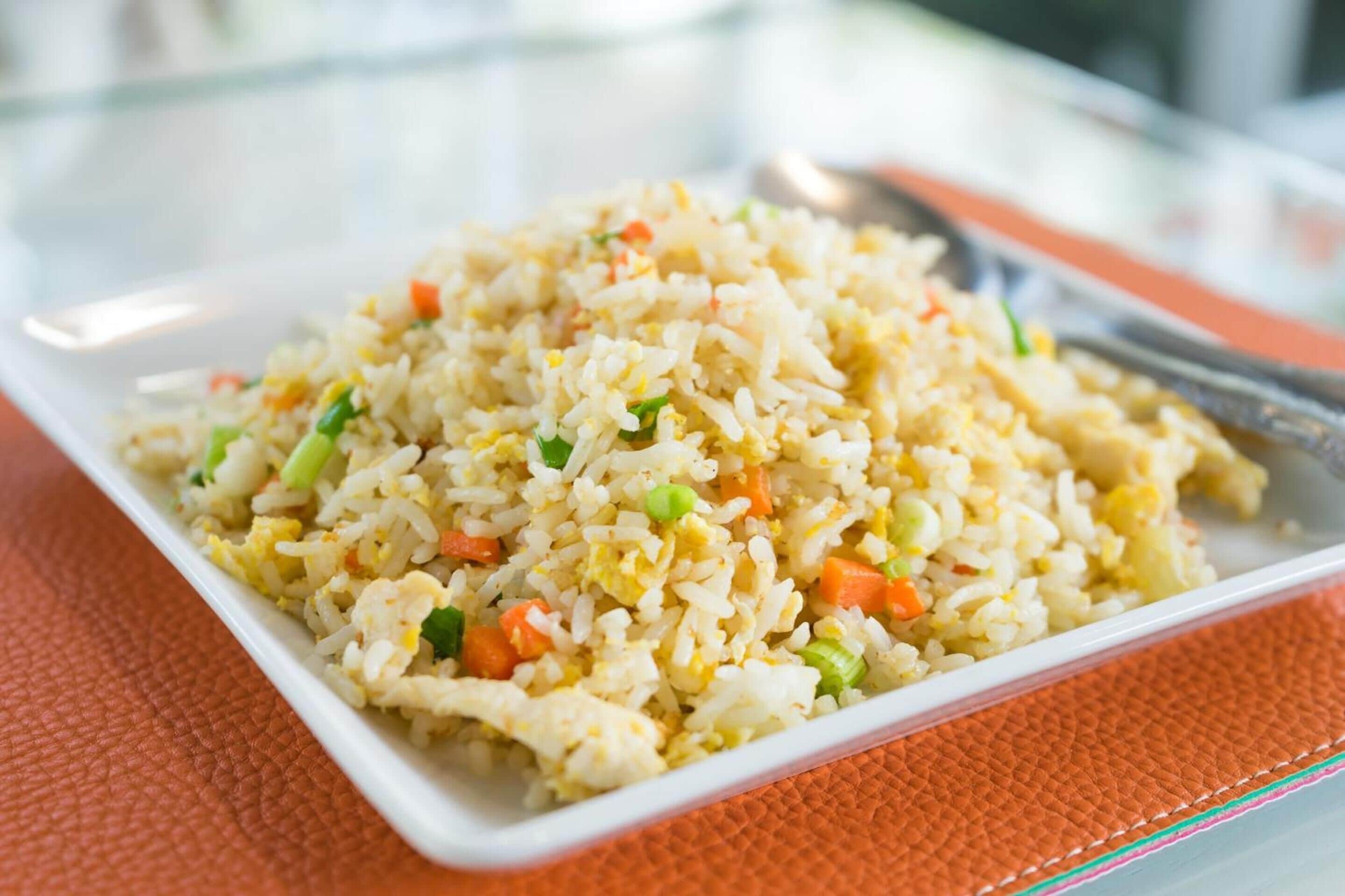 A plate of fried rice with vegetables and scrambled eggs.
