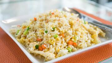 A plate of fried rice with vegetables and scrambled eggs.