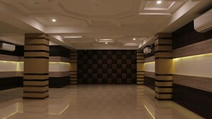 Un moderno vestíbulo de hotel con pared a cuadros, pilares a rayas e iluminación empotrada.