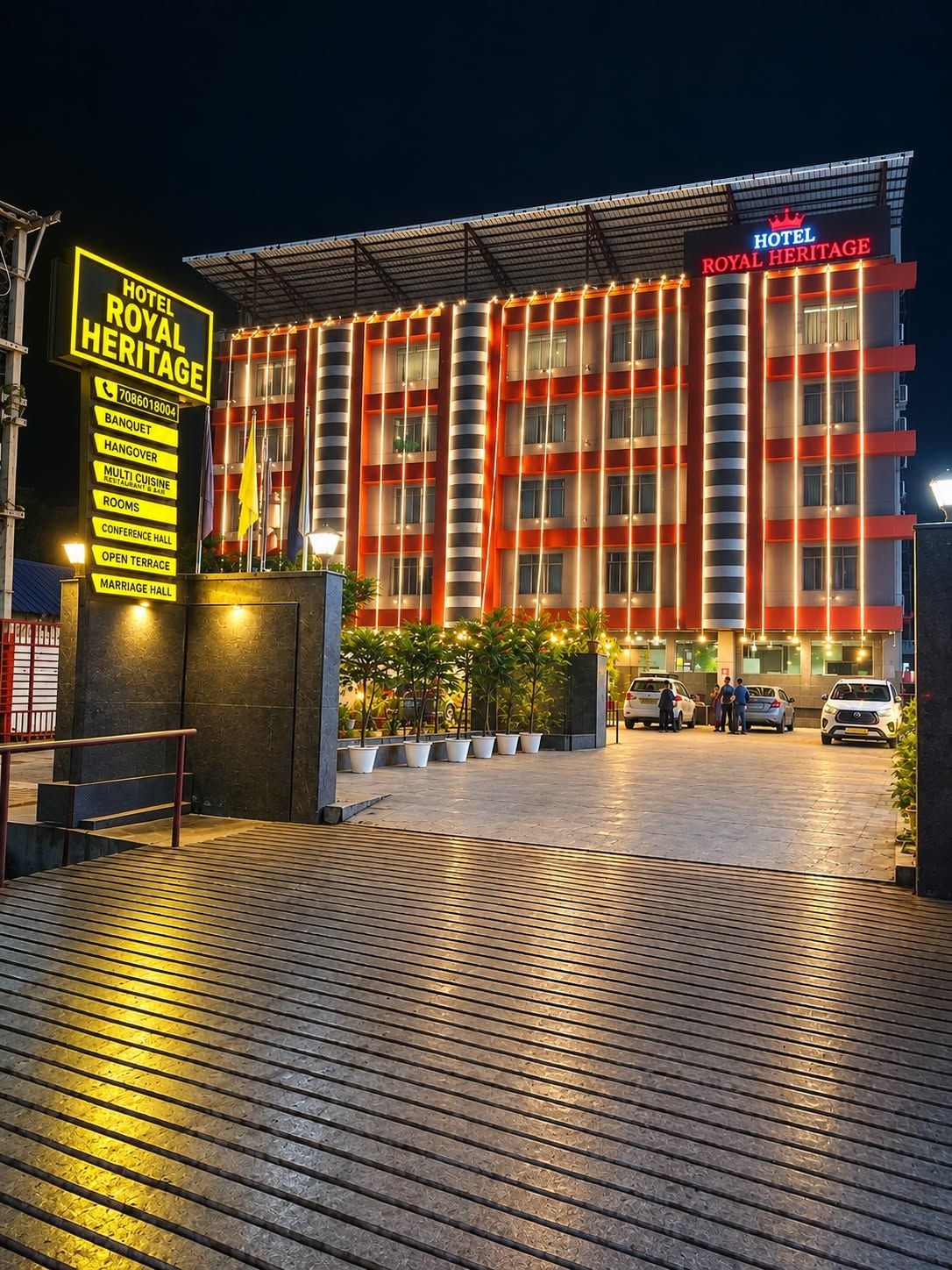 A hotel with a prominent sign, a covered entrance, and a paved driveway.