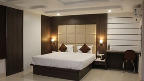 Una habitación de hotel moderna con una cama grande, mesitas de noche, un escritorio y una silla.