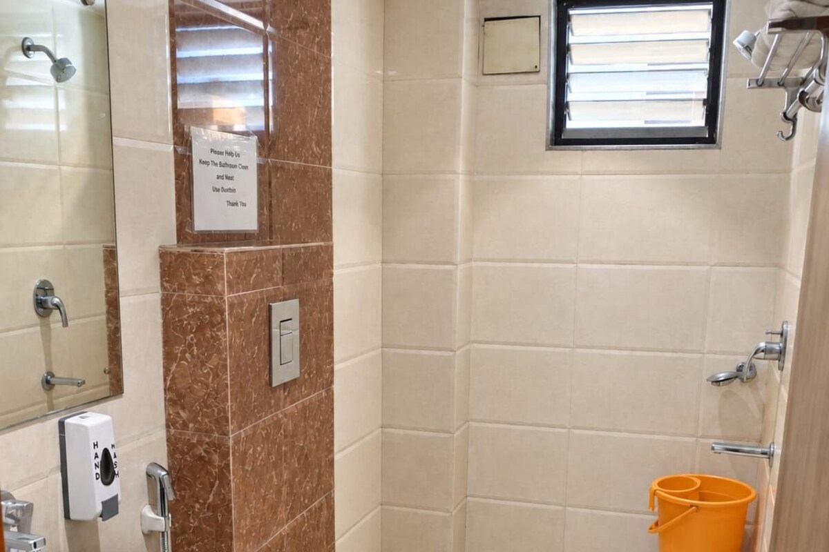 Baño con lavamanos, inodoro y zona de ducha.