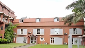 A multi-story building with a brick facade, multiple balconies, and a central entrance. - Résidence Mohili (Abidjan)
