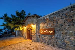 A stone building with a wooden door and a sign that reads 'Cinarlikasr1'. - Cinarli Kasri Hotel (Gökçeada)