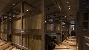 A restaurant interior with wooden paneling, herringbone patterned flooring, and a visible logo on the wall. - Hotel Route-Inn Grand Kitami Ekimae (Kitami)