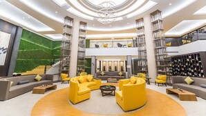 A spacious lobby with a central seating area, a staircase, and a large bookshelf. - Hilton Garden Inn Zhuji East (Shaoxing)