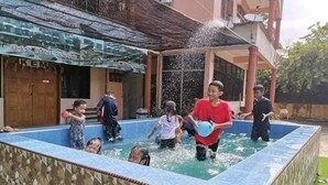 Une piscine où des enfants jouent et éclaboussent de l’eau.