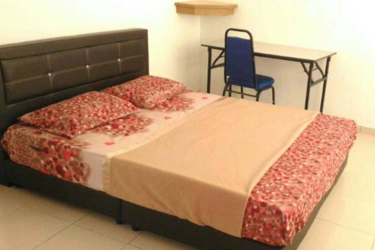 A bedroom with a bed, a desk, and a chair.