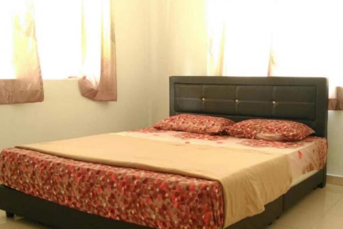 A bedroom with a bed, curtains, and a tiled floor.