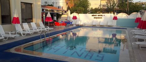Una piscina al aire libre de temporada, sombrillas