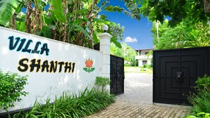 A sign for Villa Shanthini with a black gate and lush greenery. - Boutique Villa Shanthi (Hikkaduwa)