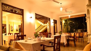 A dining area with tables set for a meal, chairs, and a staircase leading to another level. - Boutique Villa Shanthi (Hikkaduwa)