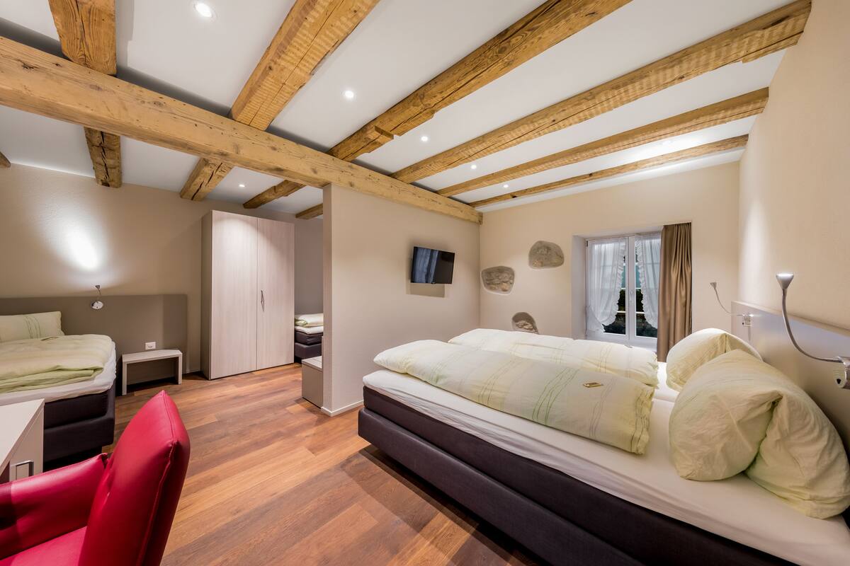 Un dormitorio con una cama grande, un escritorio, una silla y un armario.