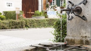 A water feature with a metal spout and a sign indicating a hotel.
