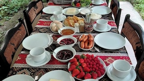 A long dining table set for a meal with various dishes and utensils. - Christy Hotel (Goris)