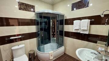 Une salle de bain avec une douche à parois de verre, des toilettes et un lavabo.