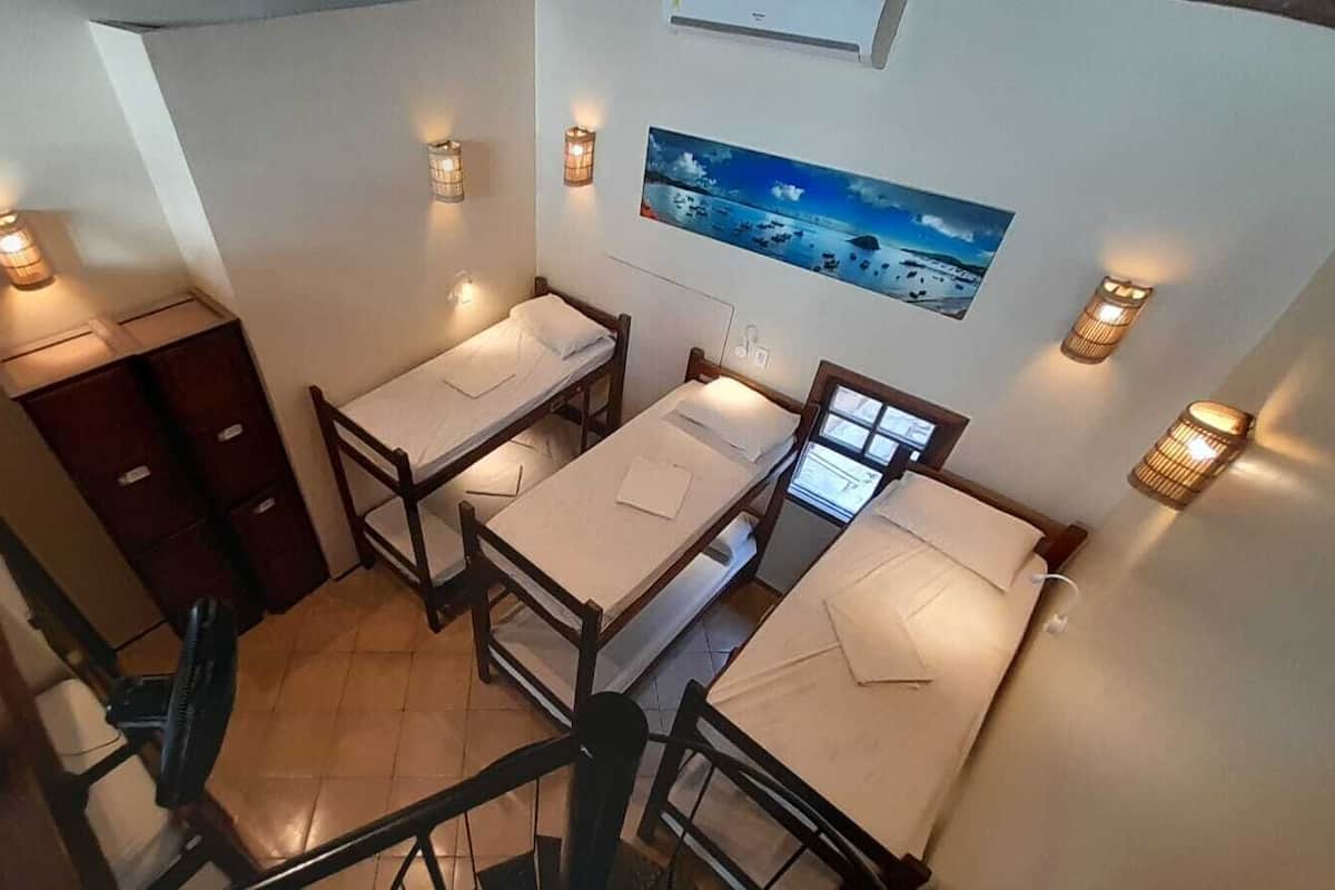 Un dormitorio con literas, un escritorio y una silla. Hay luces fijadas a la pared y un cuadro sobre las camas.