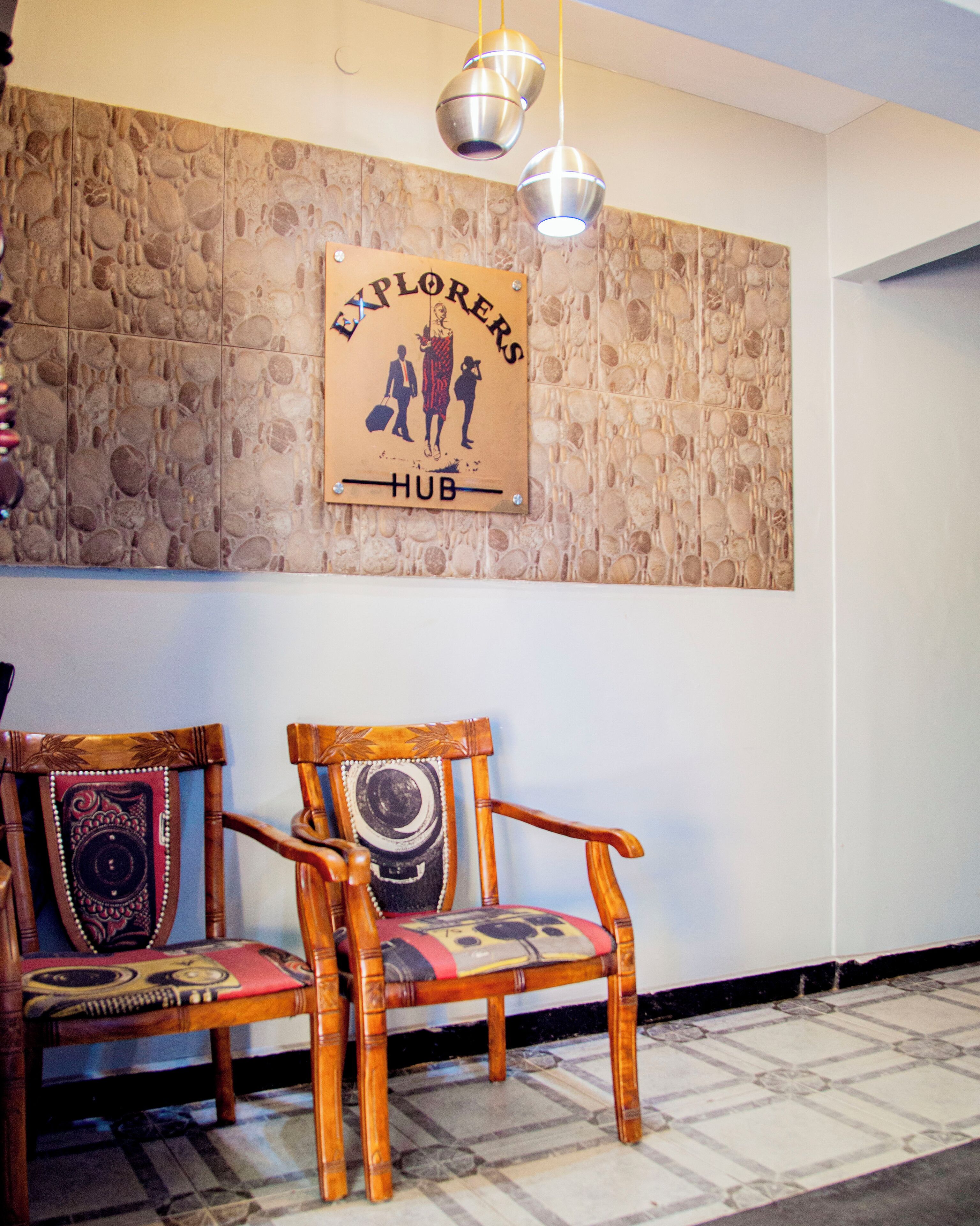 A wooden chair with a patterned cushion and a wall with a textured stone design.