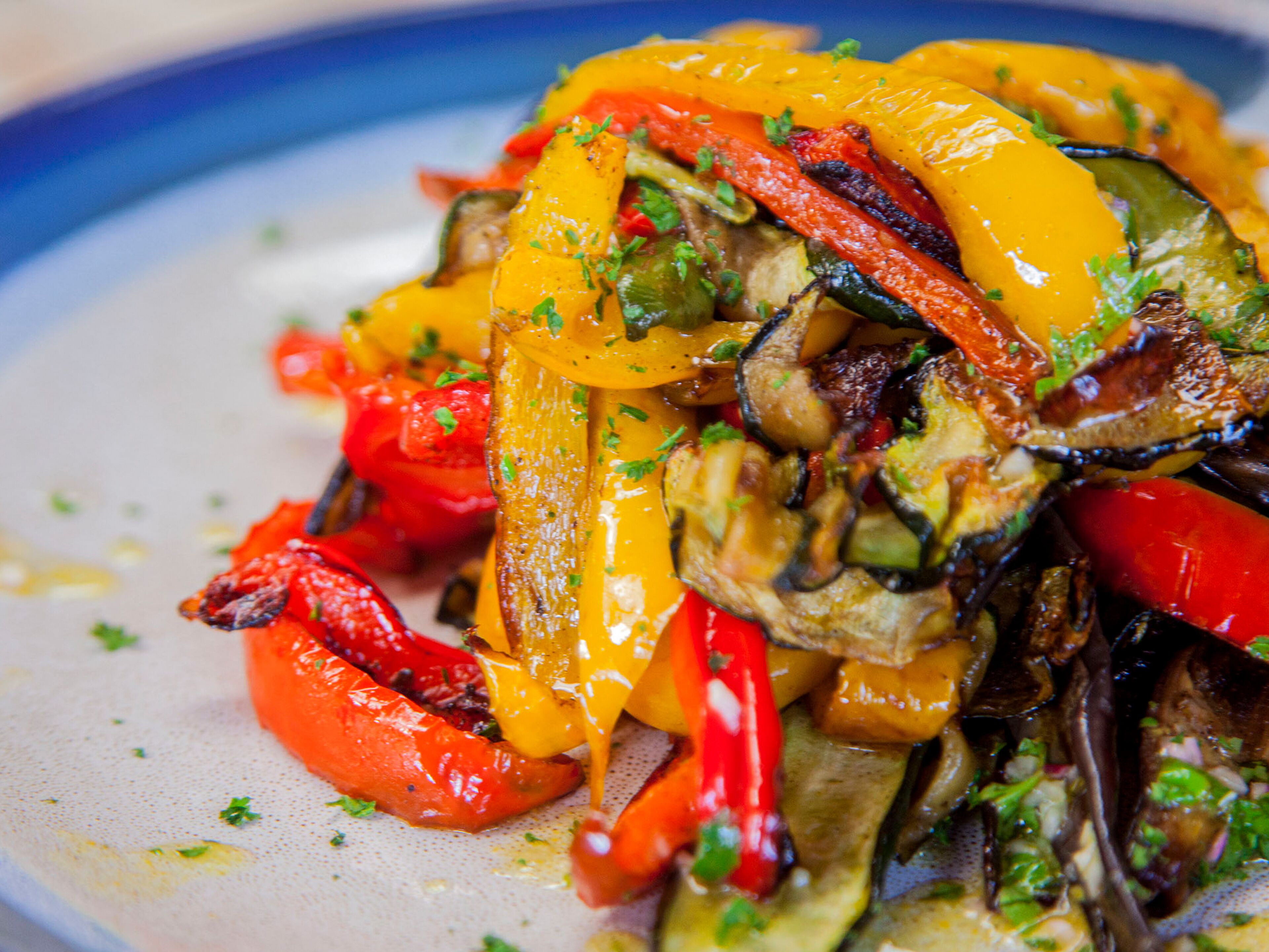 A close-up of a colorful vegetable dish with various peppers and herbs.