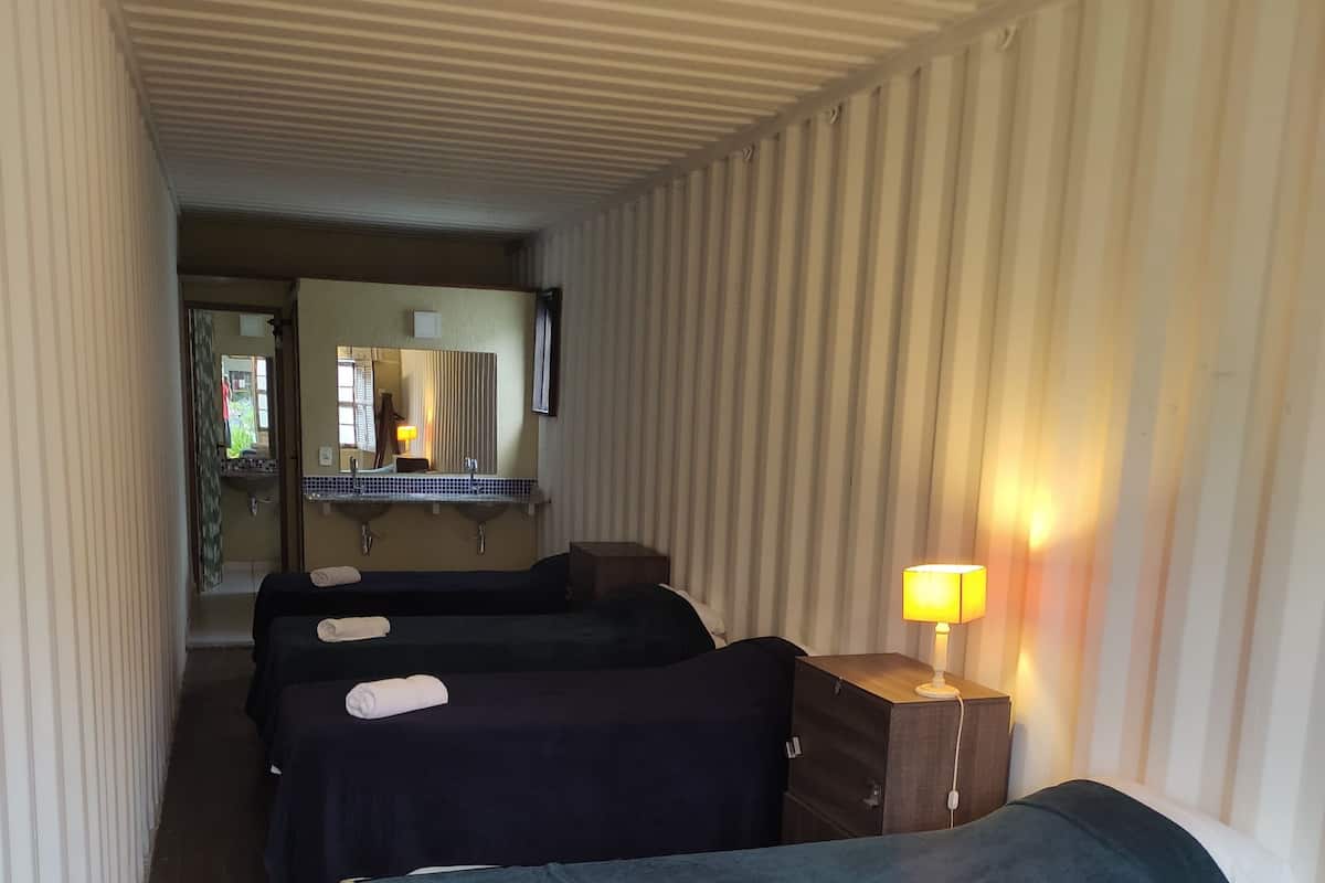 Habitación cuádruple | Tabla de planchar con plancha y ropa de cama