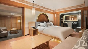 A modern hotel room with a large bed, a sitting area with a sofa and armchair, a wooden coffee table, and a bathroom with a large mirror. - Chengdu Bvstin Boutique Hotel (Chengdu)