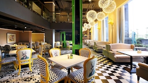 A restaurant with a checkered floor, yellow and black chairs, and a green pillar. - Chengdu Bvstin Boutique Hotel (Chengdu)