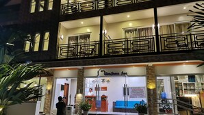 Ein Hotel mit einer Rezeption, einer Treppe und einem Balkon mit Geländern.