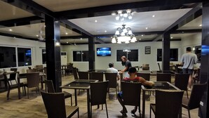 Ein geräumiges Restaurant mit hohen Decken, moderner Beleuchtung und bequemen Sitzgelegenheiten.