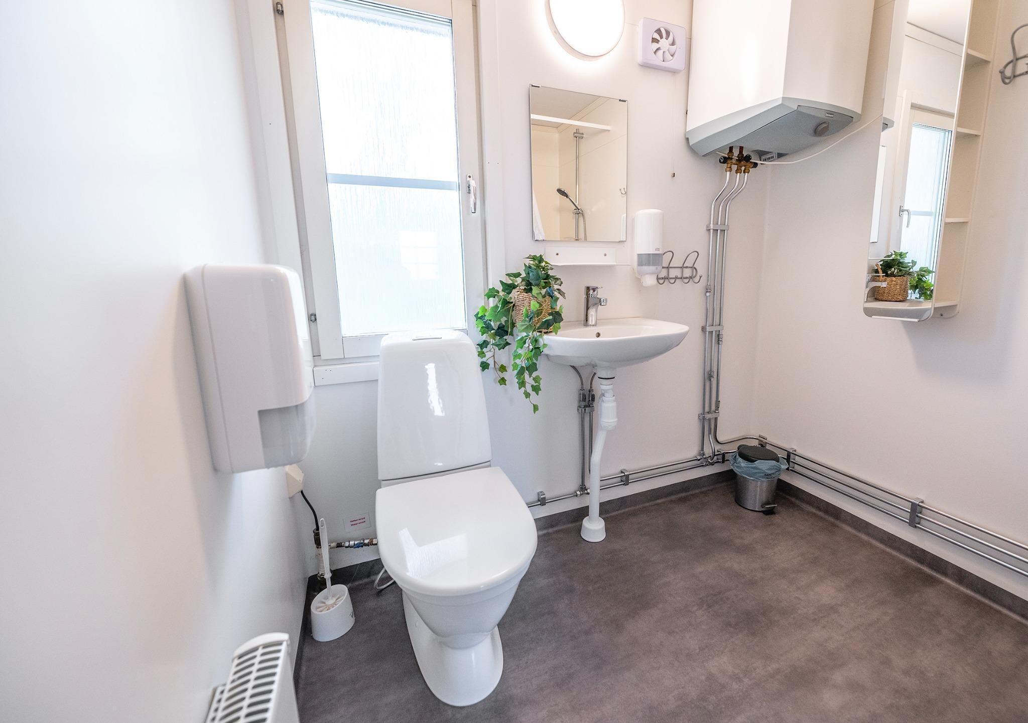 A modern bathroom with a toilet, sink, and shower.