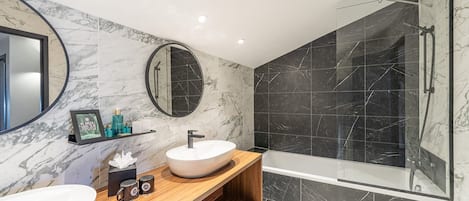 A modern bathroom with two sinks, a large mirror, and a glass-enclosed shower.