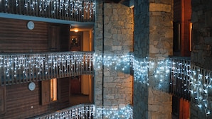 A multi-level building with stone walls and wooden balconies, decorated with string lights. - Fahrenheit seven Courchevel (Courchevel)