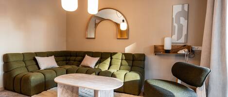Una sala de estar moderna con un sofá modular, una mesa de centro y un sillón.