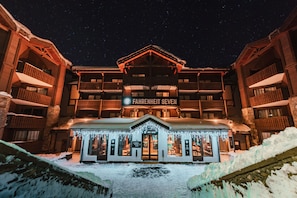 Ein Hotel mit einem Schild mit der Aufschrift 'FAHRENHEIT SEVEN', Balkonen und dem Eingang zu einer Skibar.