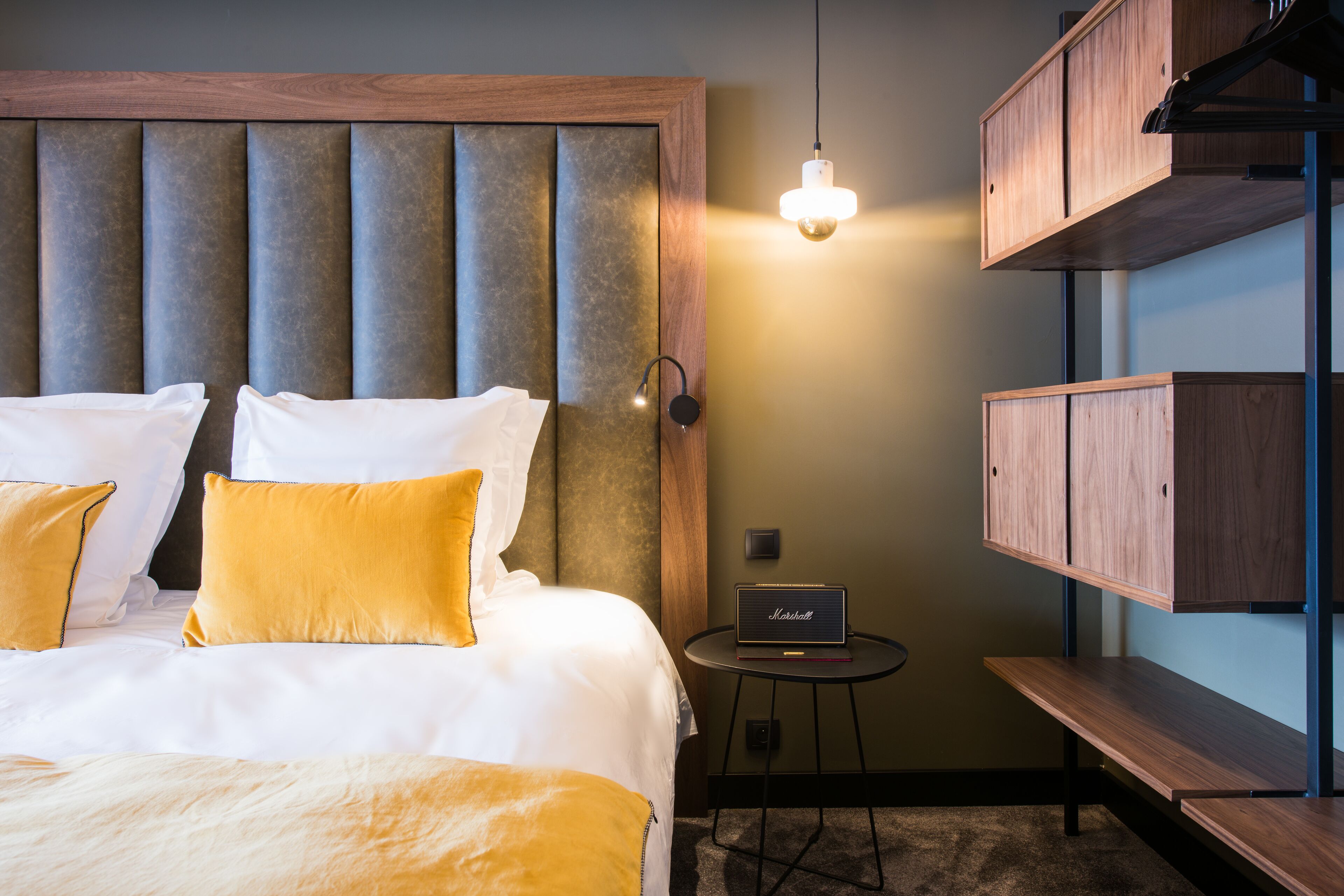 Ein Hotelzimmer mit einem großen Bett, einem Nachttisch mit Lampe und eingebauten Holzböden.