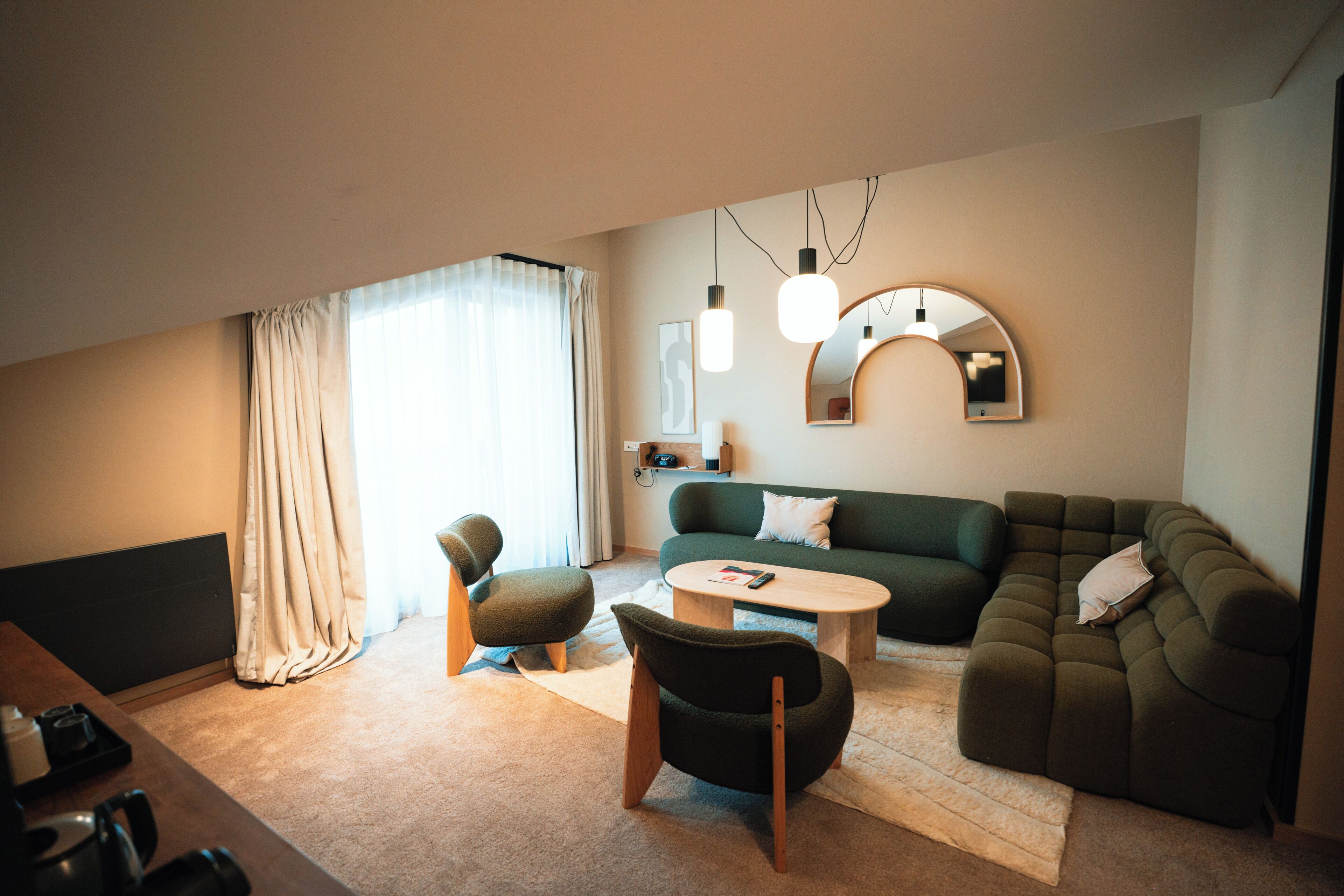 A modern living room with a sofa, chairs, a coffee table, and a TV.