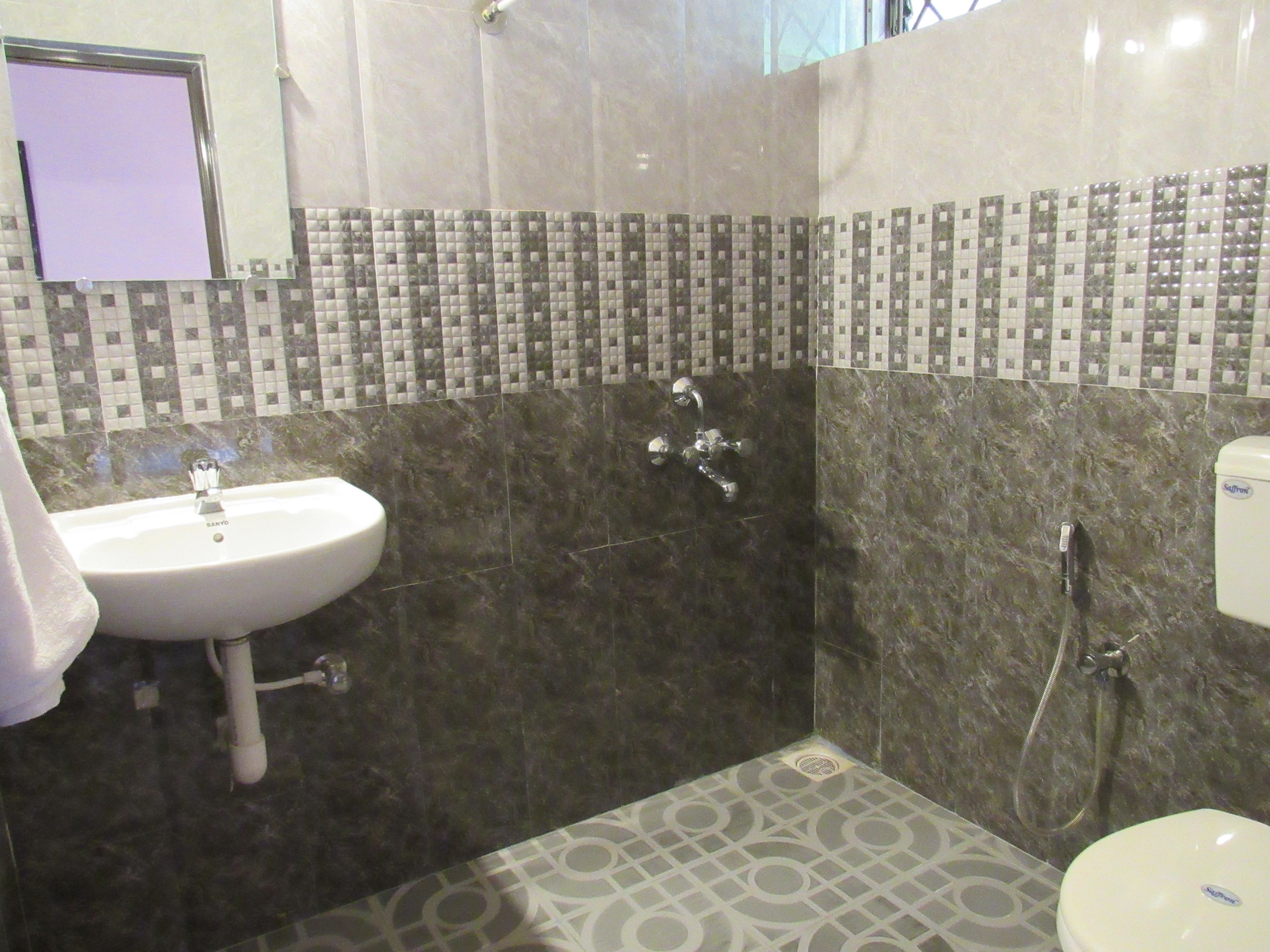 A bathroom with a sink, a shower, and a toilet.