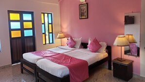 Un dormitorio con cama, mesitas de noche, lámpara, un marco de cuadro y ventana con vistas.